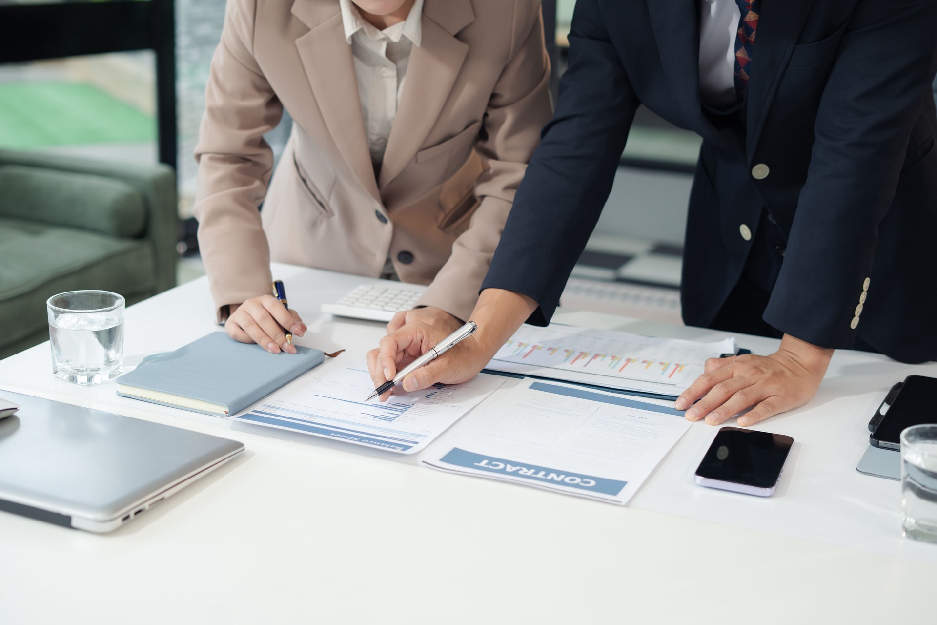 Business consultants discuss tax, merger strategy and restructuring in modern office.